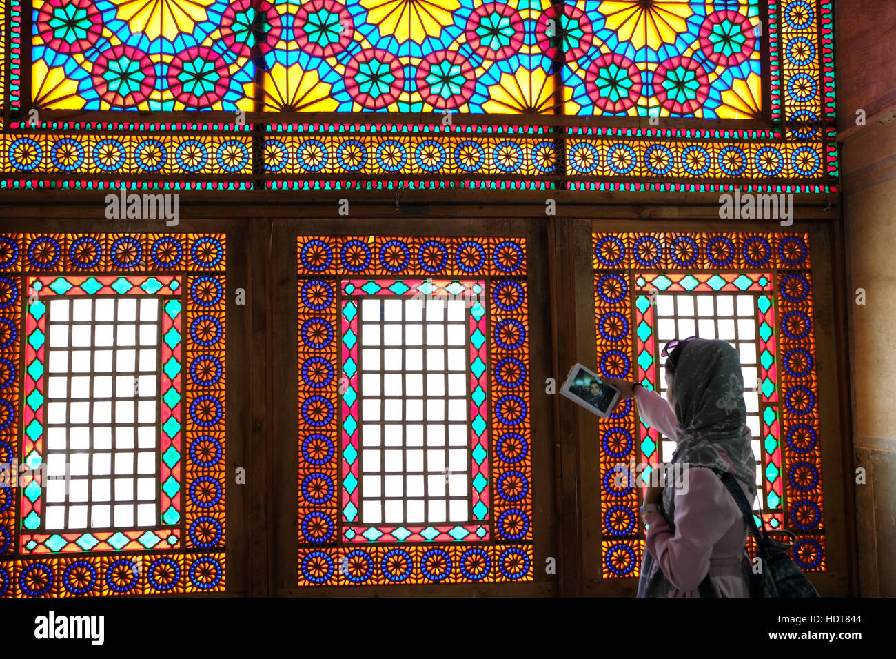 Un turista fotografie finestre di vetro colorato all'interno della storica casa Qavam in Shiraz, far Provincia, Iran Foto Stock