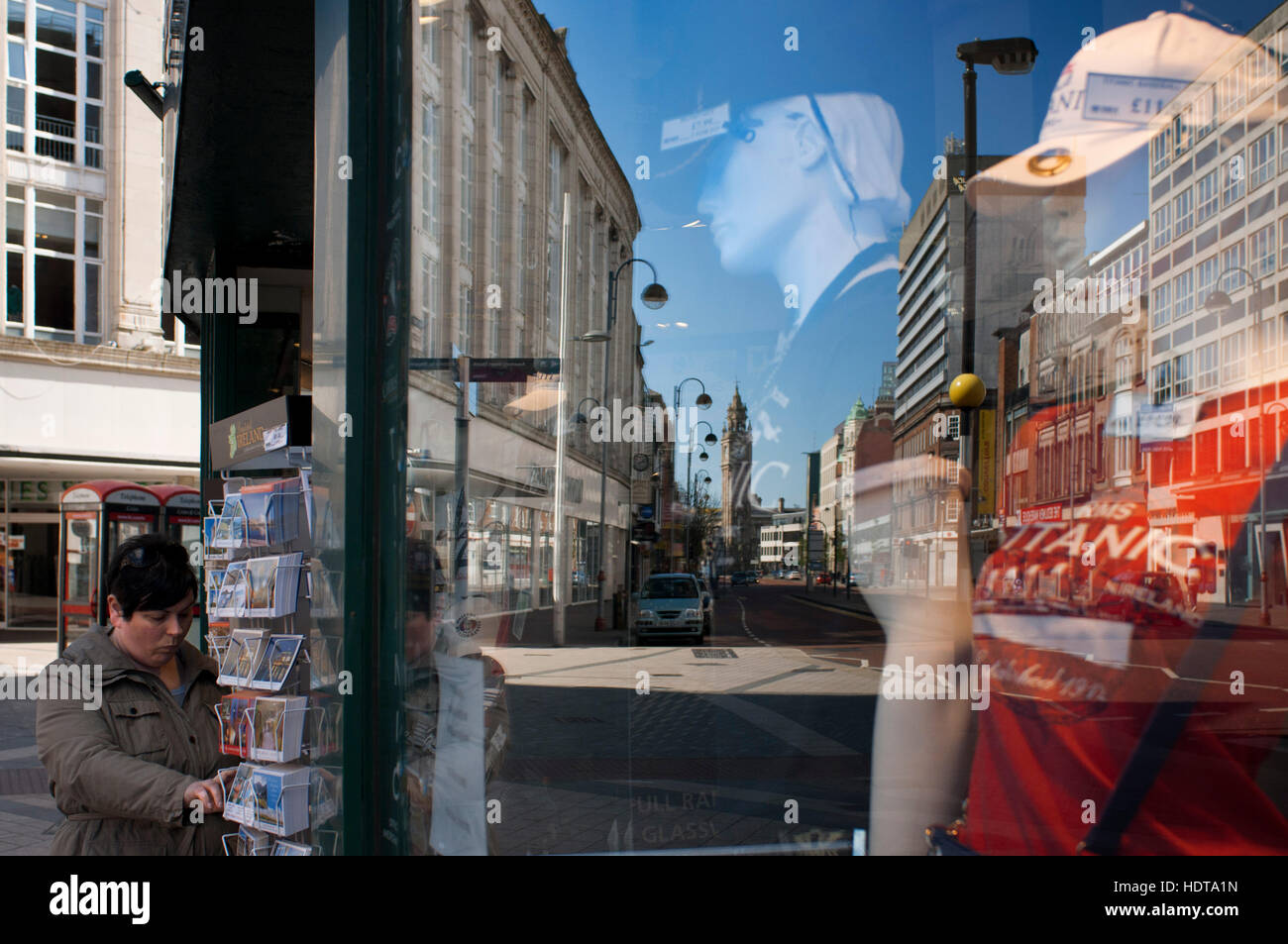 Riflessioni in una finestra di uno dei negozi nel centro di Belfast, Irlanda del Nord, Regno Unito. Tutti i soliti grandi magazzini di fascia alta e le catene sono l Foto Stock