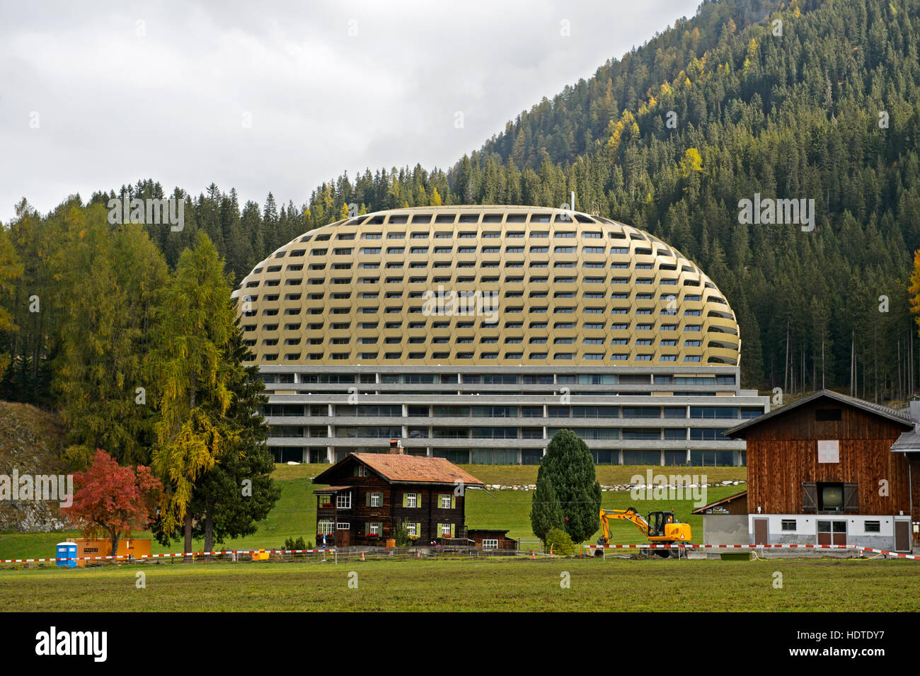 Vecchia casa colonica svizzero nella parte anteriore del moderno InterContinental Hotel di Davos, Davos, Grigioni, Svizzera Foto Stock