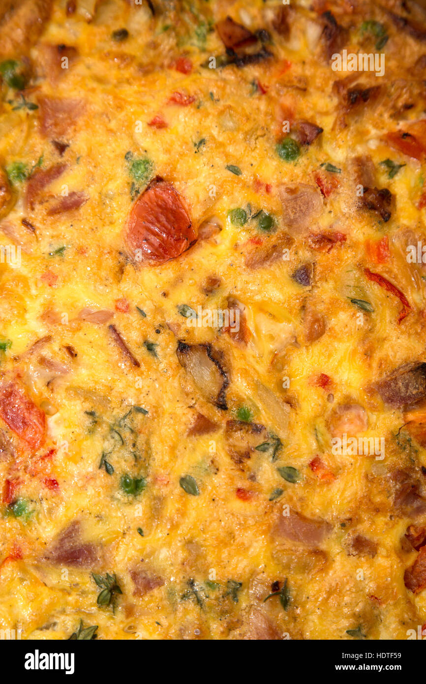 Stile Italiano frittata, uova ricetta pomodori cipolle, i piselli e i peperoni in capsula di vetro Foto Stock