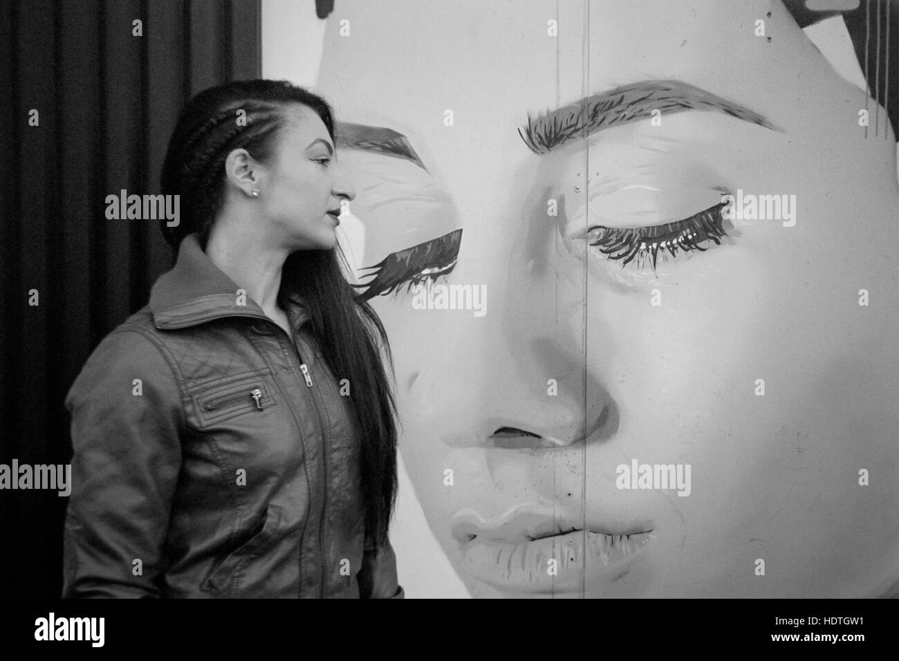 Giovane bella femmina pone accanto alla parete art graffiti southsea England Regno Unito Foto Stock