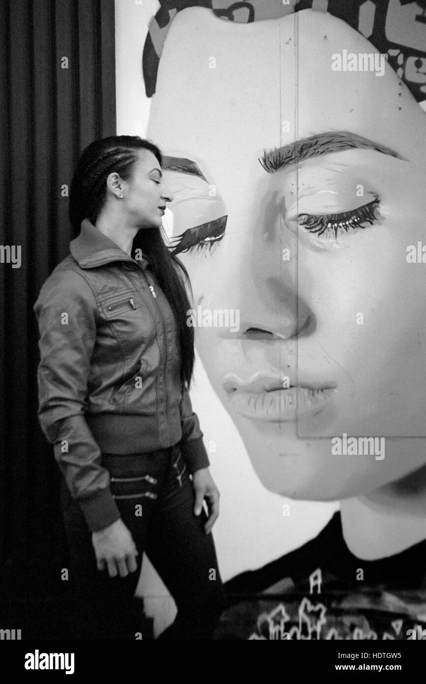 Giovane bella femmina pone accanto alla parete art graffiti southsea England Regno Unito Foto Stock