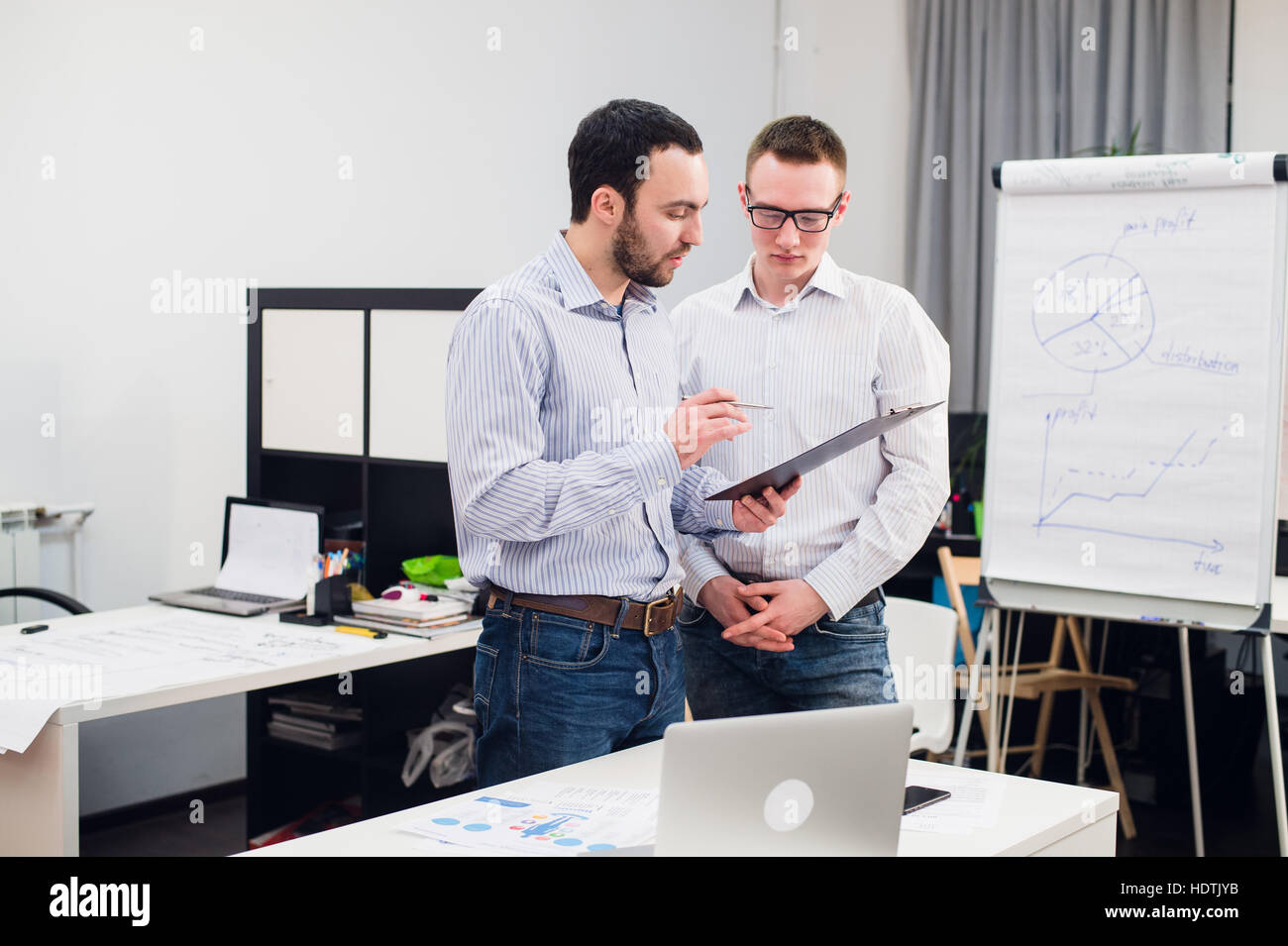 Due caucasici i dirigenti aziendali in abbigliamento casual avente una discussione aziendale in ufficio. Foto Stock