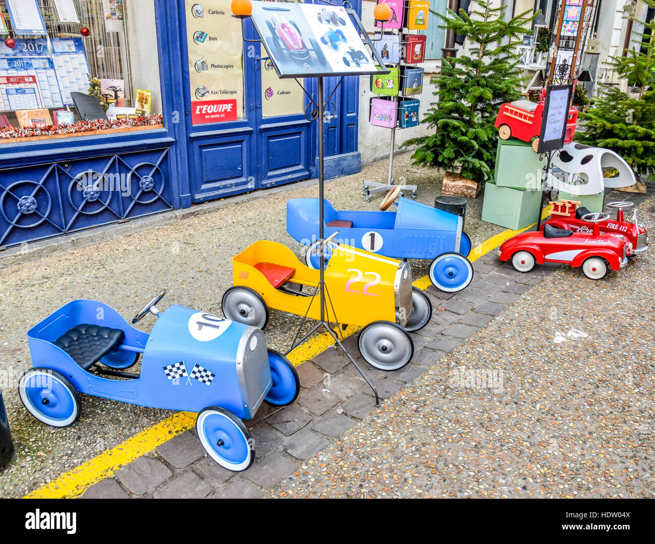 Dimensioni Toddler automobili giocattolo sedersi al di fuori di un negozio in Francia, in attesa di nuovi proprietari. Foto Stock