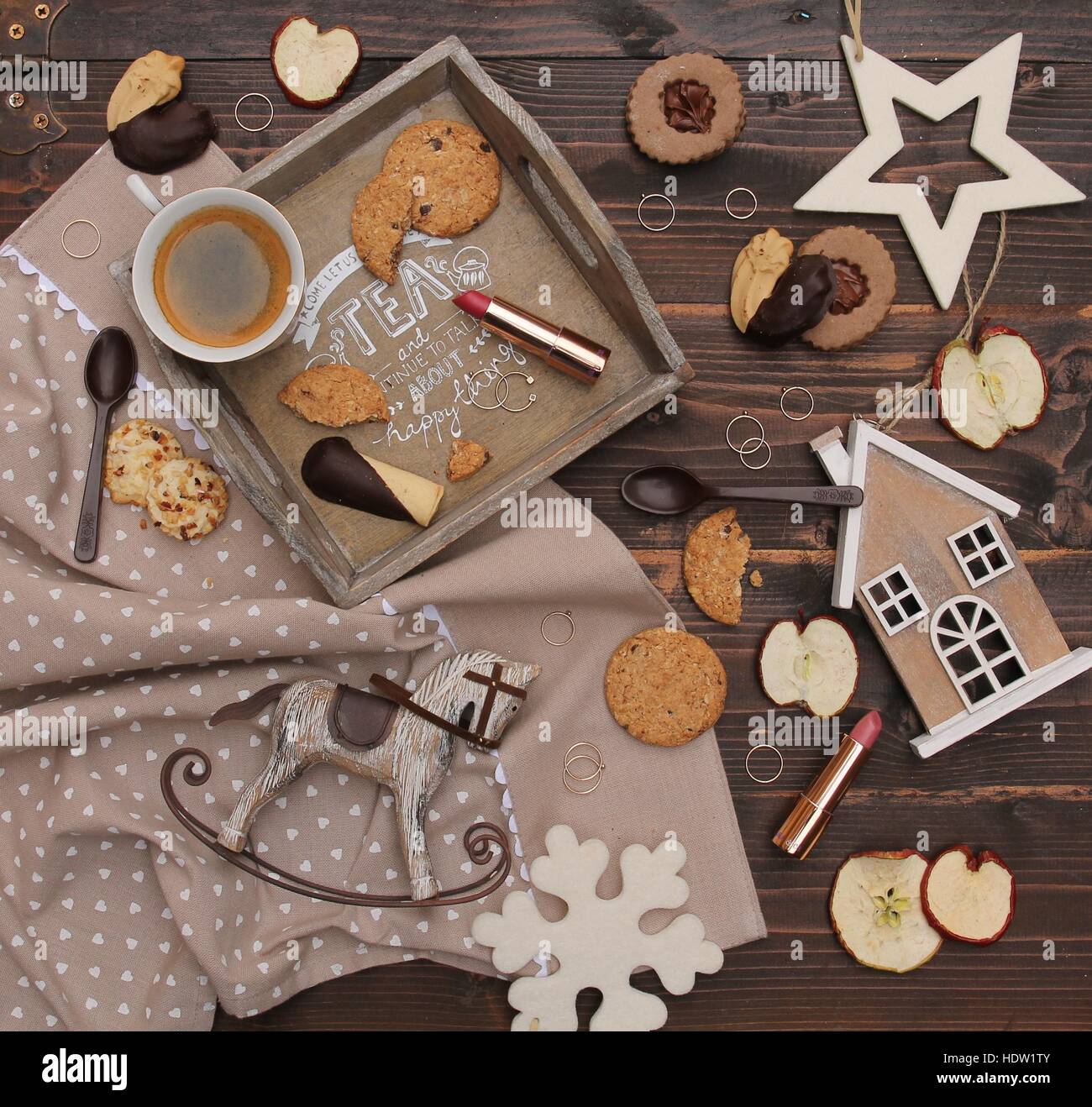 Festive flatlay con i cookie, tradizionali biscotti secchi fette di mela, le decorazioni di Natale, anelli, caffè e make-up prodotto Foto Stock