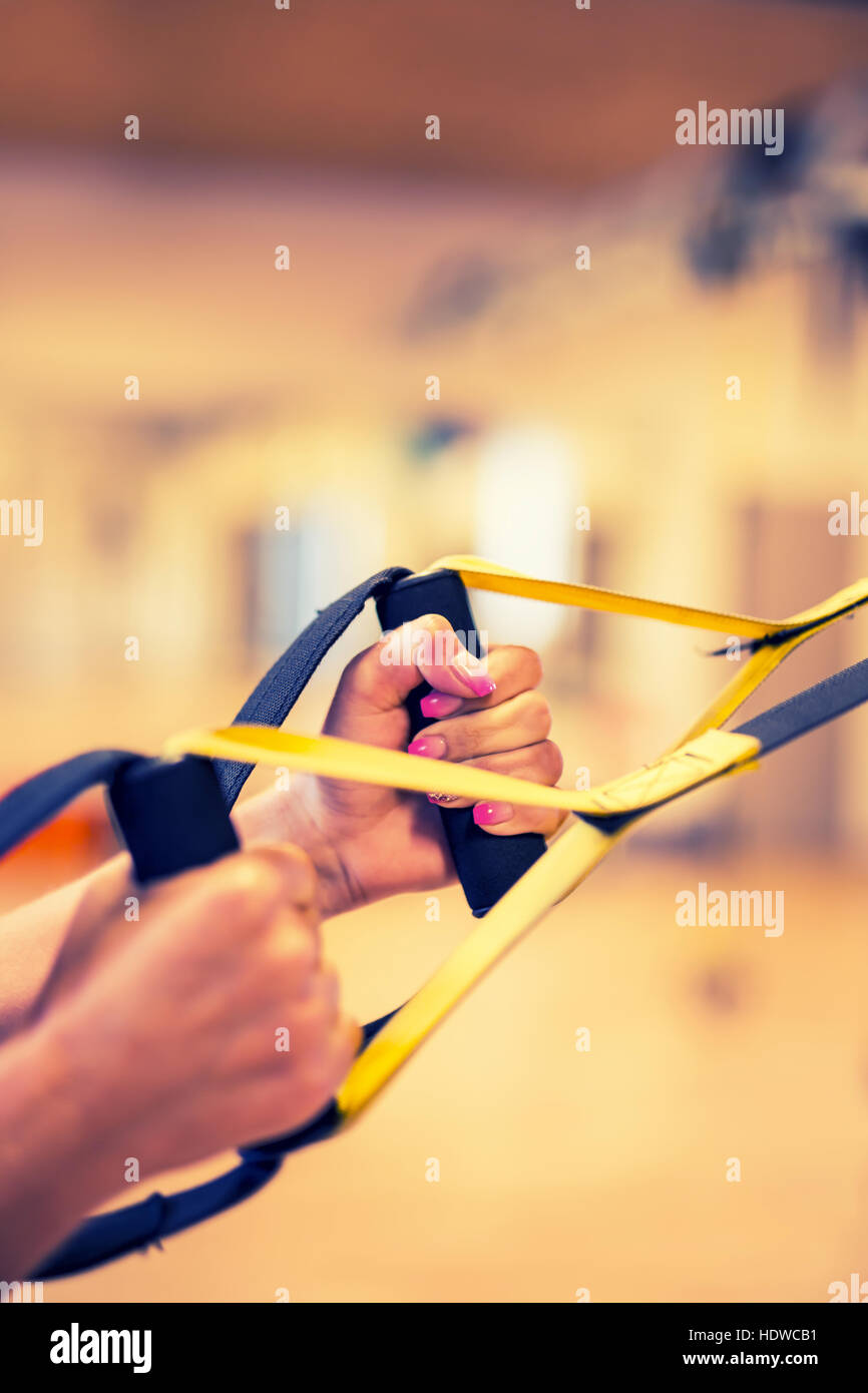 TRX. Mani femminili con fitness TRX cinghie in palestra. Foto Stock