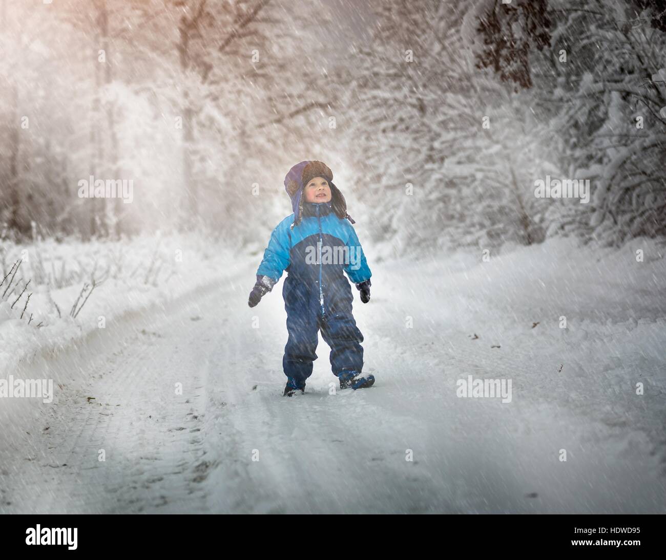 Ragazzo giocando in grande neve in inverno. Felice bambino caucasico giocare nella neve. Foto Stock