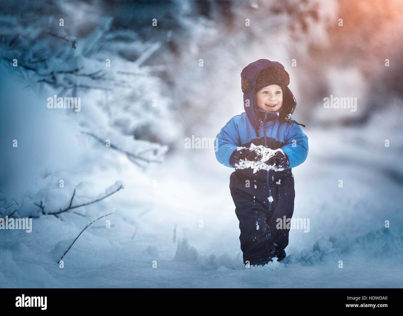 Ragazzo giocando in grande neve in inverno. Felice bambino caucasico giocare nella neve. Foto Stock