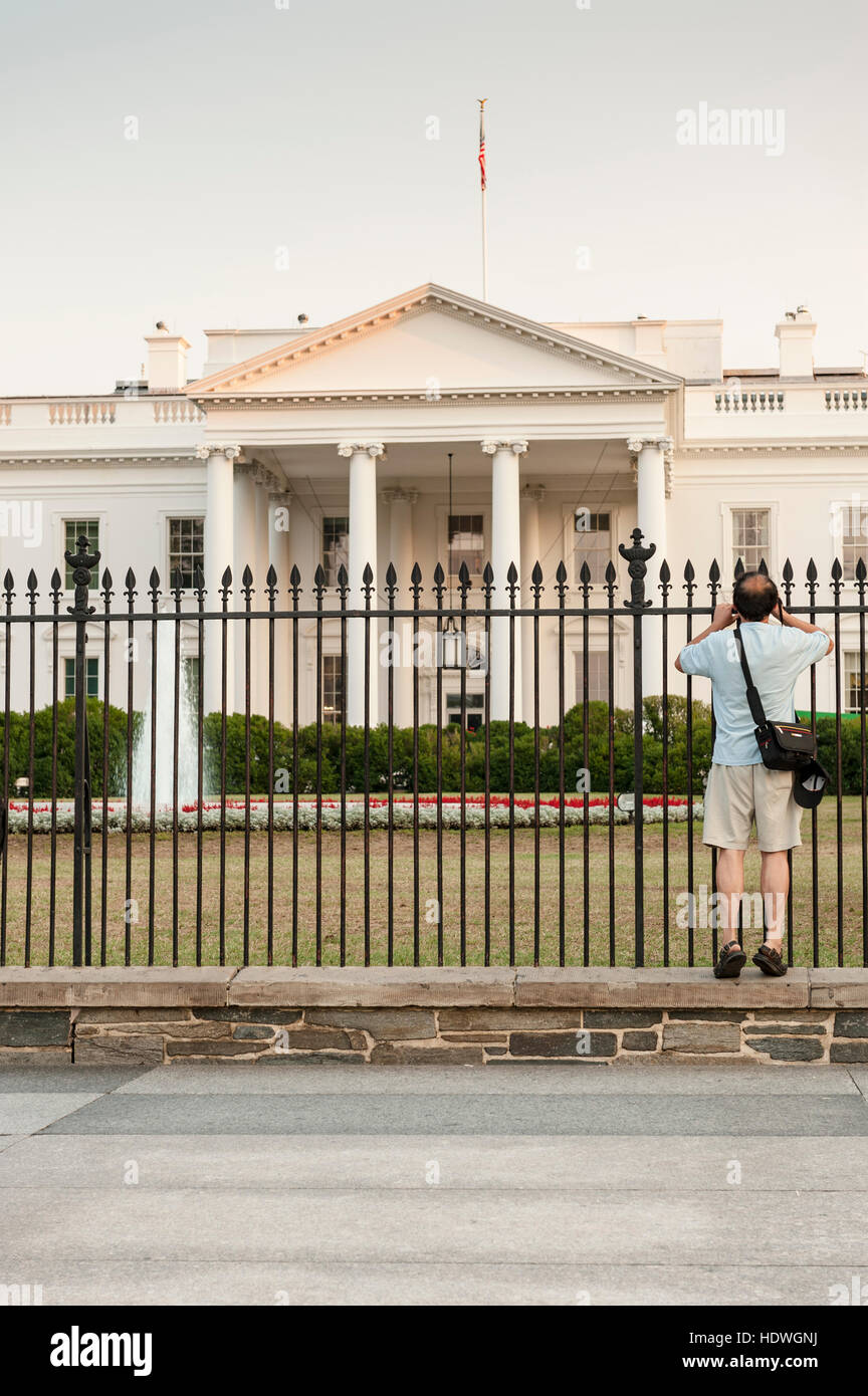 Washington, DC - un picchi turistici attraverso la Casa Bianca cortile anteriore recinto cercando di ottenere un angolo di chiara a fotografare. Foto Stock