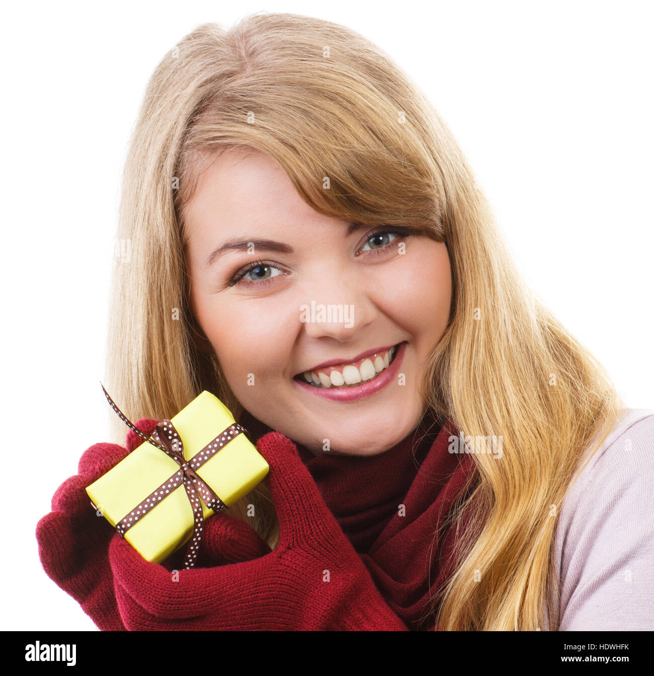 Donna sorridente in guanti di lana avvolto di contenimento regalo per Natale, Valentino, compleanno o altra celebrazione, sfondo bianco Foto Stock