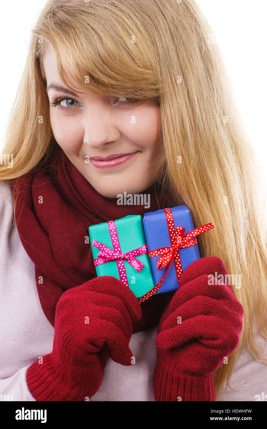 Donna sorridente in guanti di lana avvolto di contenimento di regali di Natale, Valentino, compleanno o altra celebrazione, sfondo bianco Foto Stock