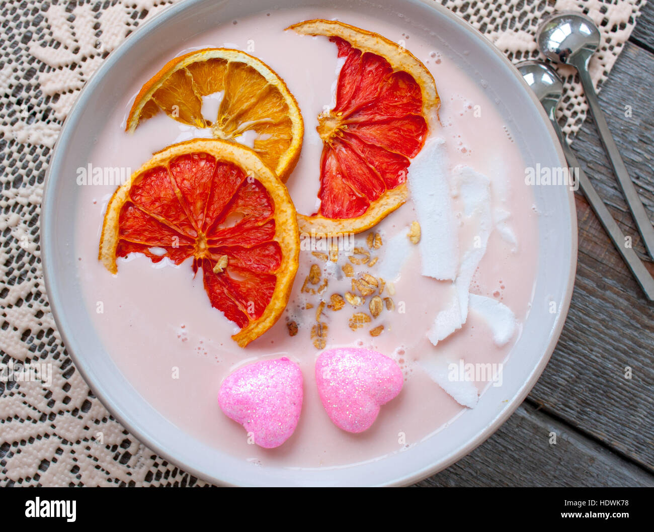 Frullati rosa con lampone, noce di cocco, arance e granola. La prima colazione il giorno di San Valentino. Foto Stock