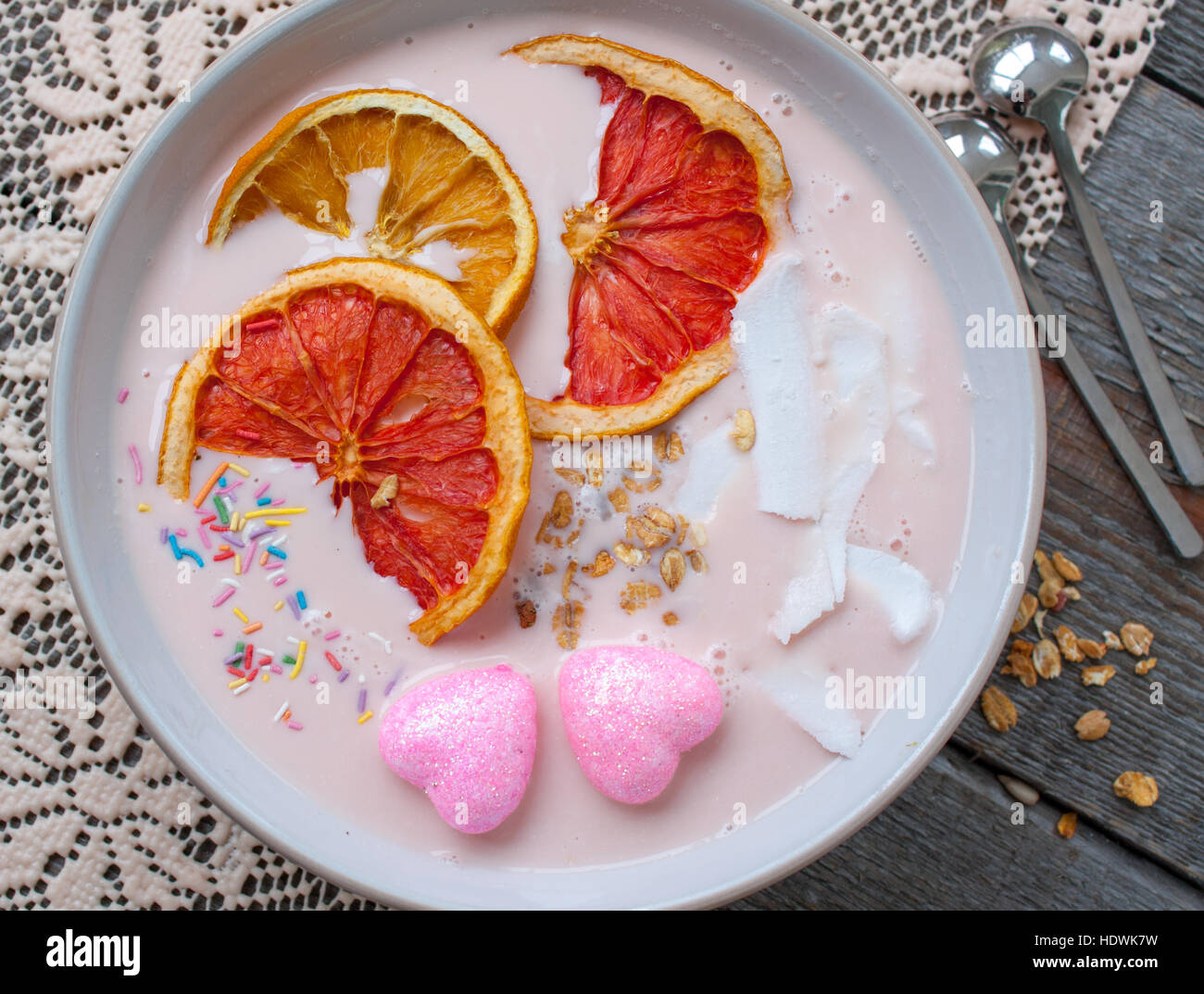 Frullati rosa con lampone, noce di cocco, arance e granola. La prima colazione il giorno di San Valentino. Foto Stock
