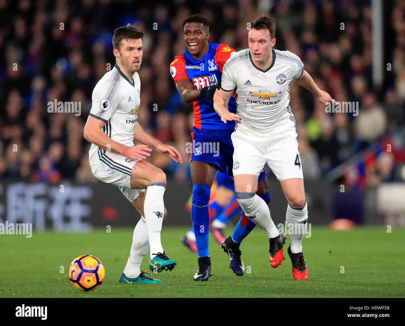 Il palazzo di cristallo di Wilfried Zaha battaglie per la palla con il Manchester United Michael Carrick (sinistra) e Phil Jones (a destra) durante il match di Premier League a Selhurst Park, Londra. Foto Stock