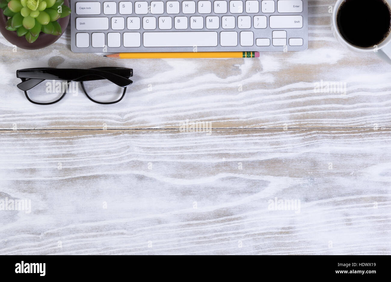 Vista aerea di un bordo superiore di lavoro desktop oggetti correlati più una tazza di caffè scuro. Foto Stock