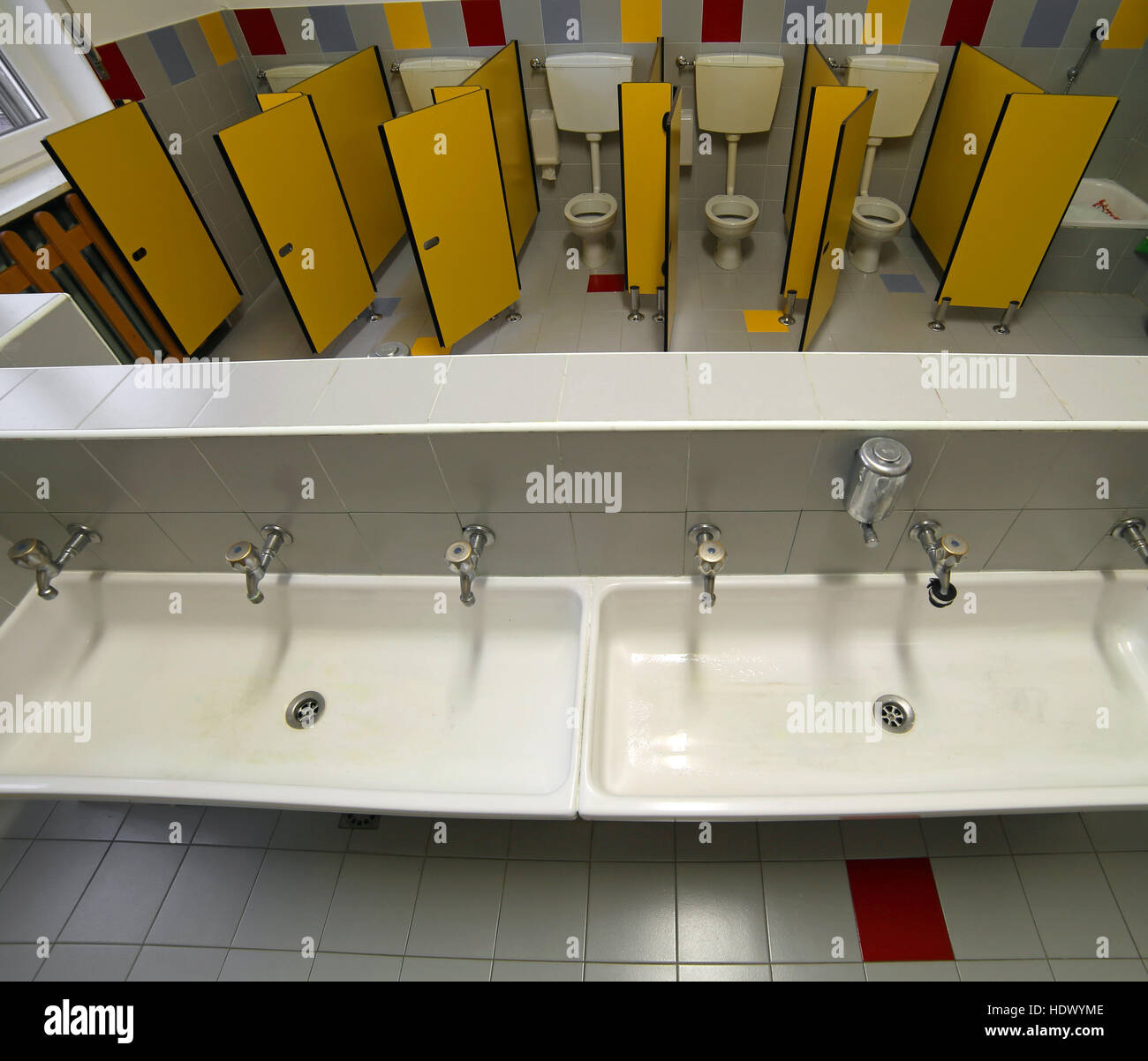 All'interno di un bagno di una scuola materna con piccoli bagni e lunga grandi lavelli Foto Stock