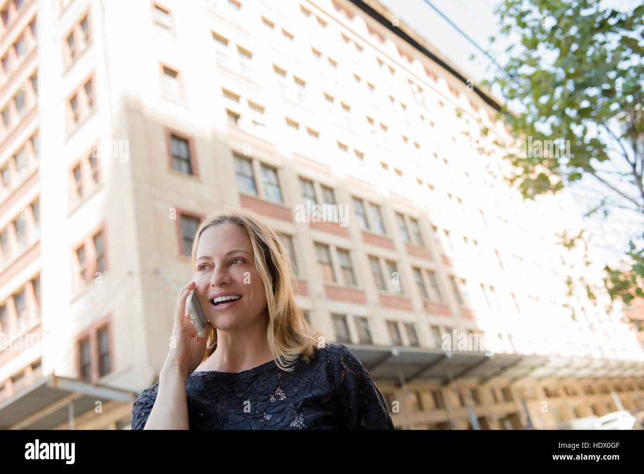 La donna caucasica parlando al cellulare in città Foto Stock