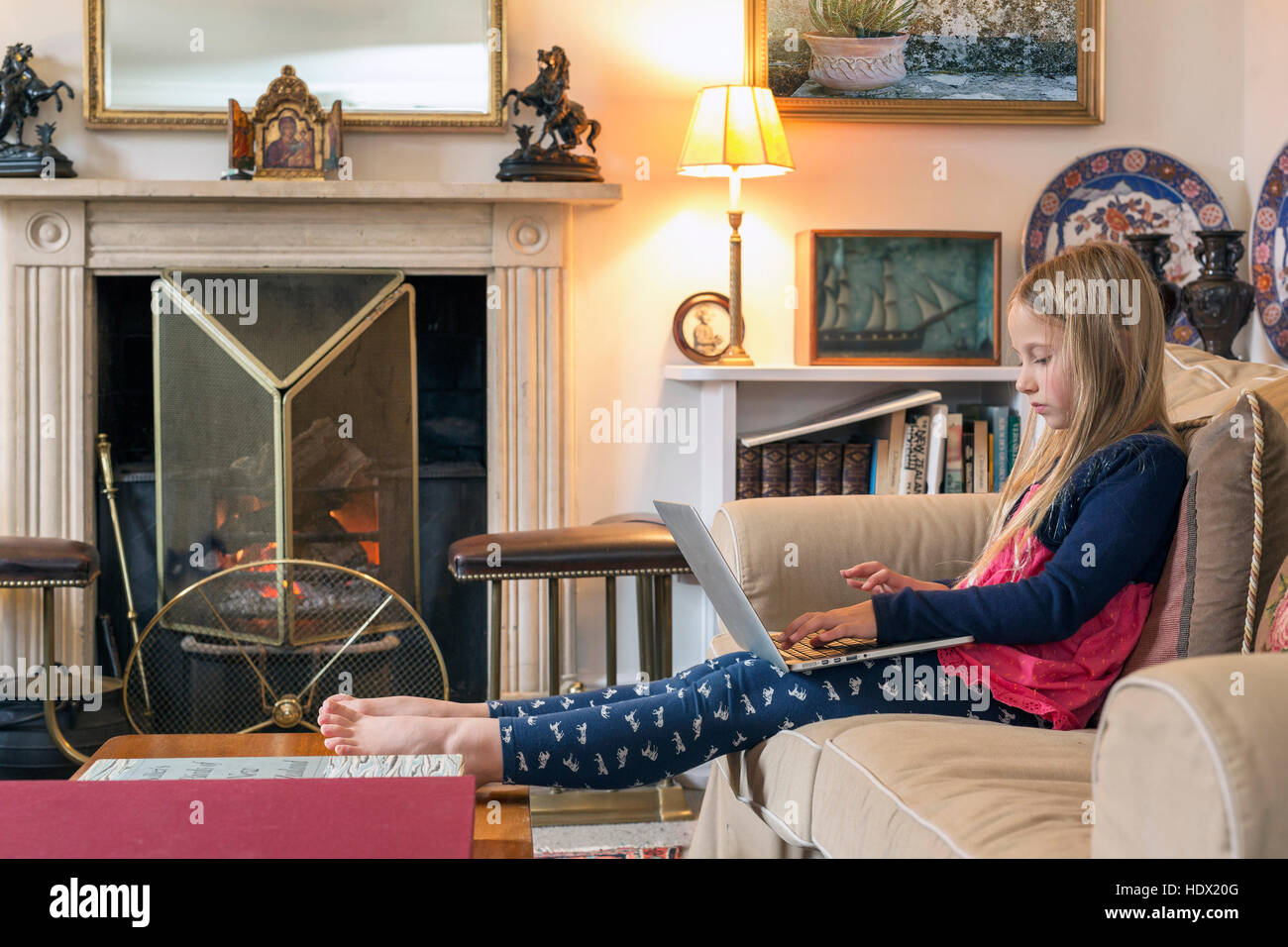 Caucasian ragazza seduta sul divano con laptop Foto Stock