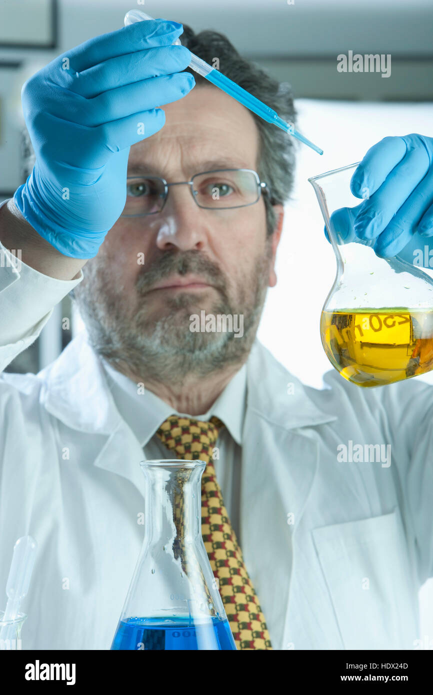 Scienziato caucasica liquido di miscelazione in laboratorio Foto Stock