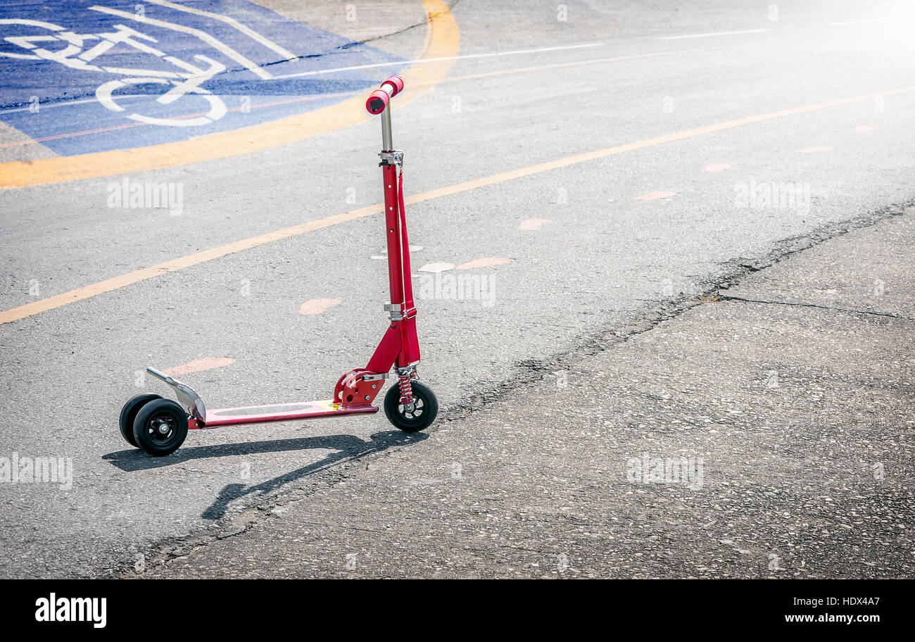 Red scooter sulla strada asfaltata Foto Stock