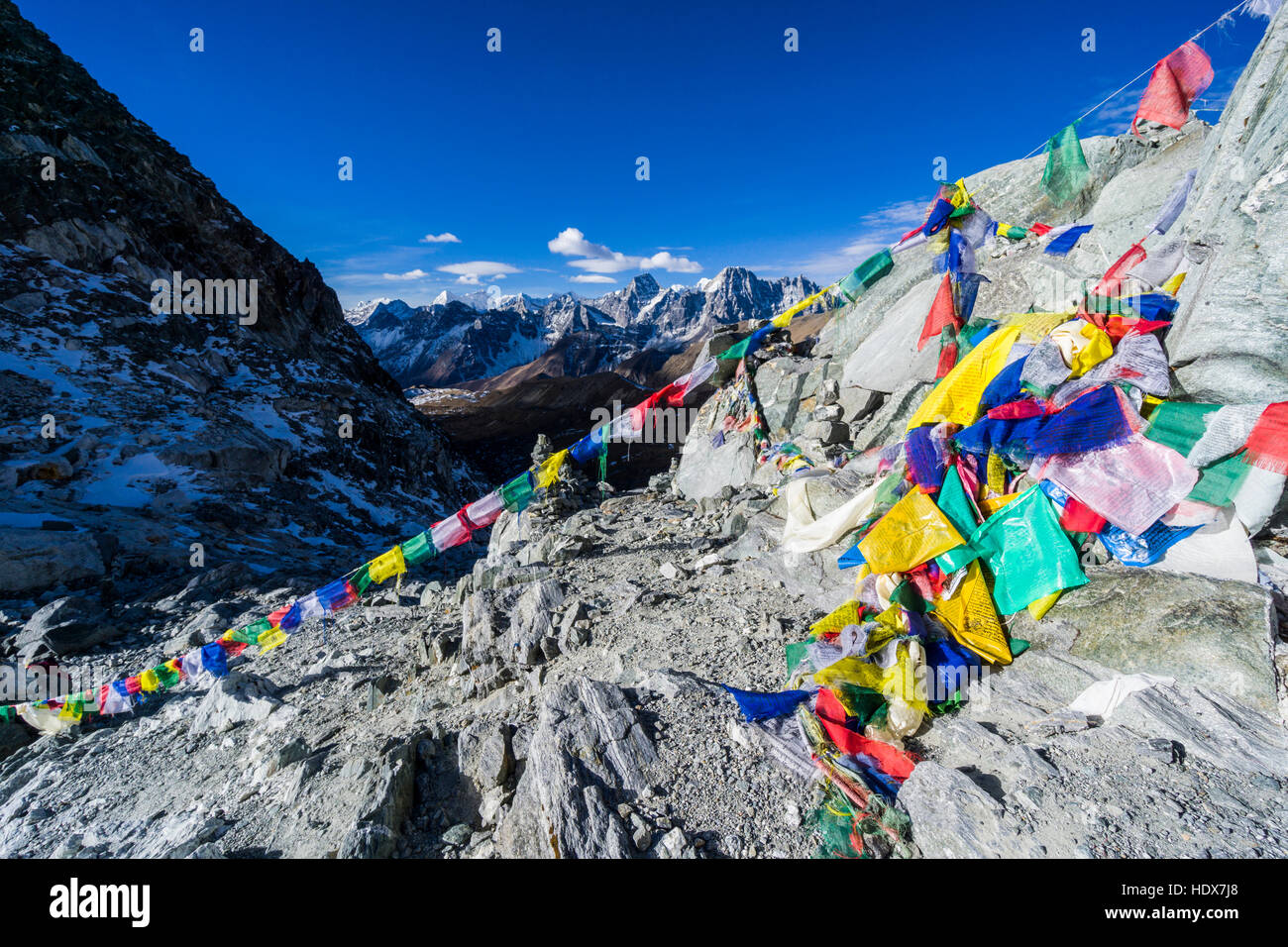 Colorati bandiere di preghiera sul cho la (5420m), montagne coperte di neve in lontananza Foto Stock