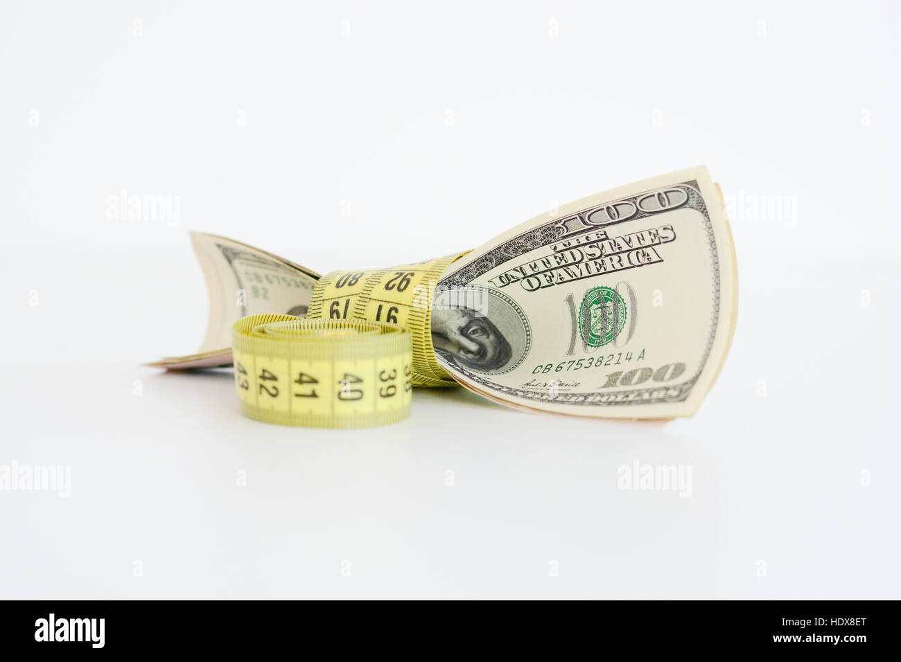 Le fatture del dollaro legata con giallo nastro di misurazione suggerendo la misura di stato finanziario Foto Stock