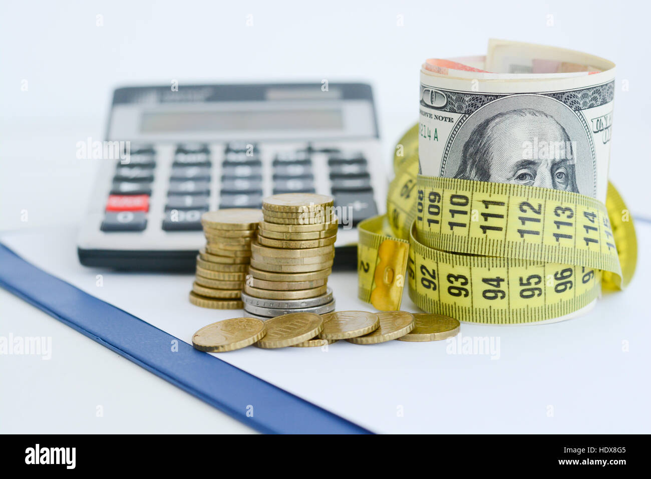 Le fatture del dollaro legata con giallo nastro di misurazione suggerendo la misura di stato finanziario Foto Stock