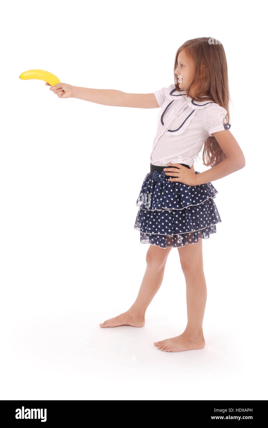 Una giovane ragazza detiene banana isolato su sfondo bianco Foto Stock