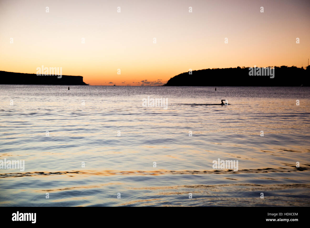 Braccio di un nuotatore fuoriesce dell'acqua metà corsa nuoto in mare prima del sorgere del sole Foto Stock