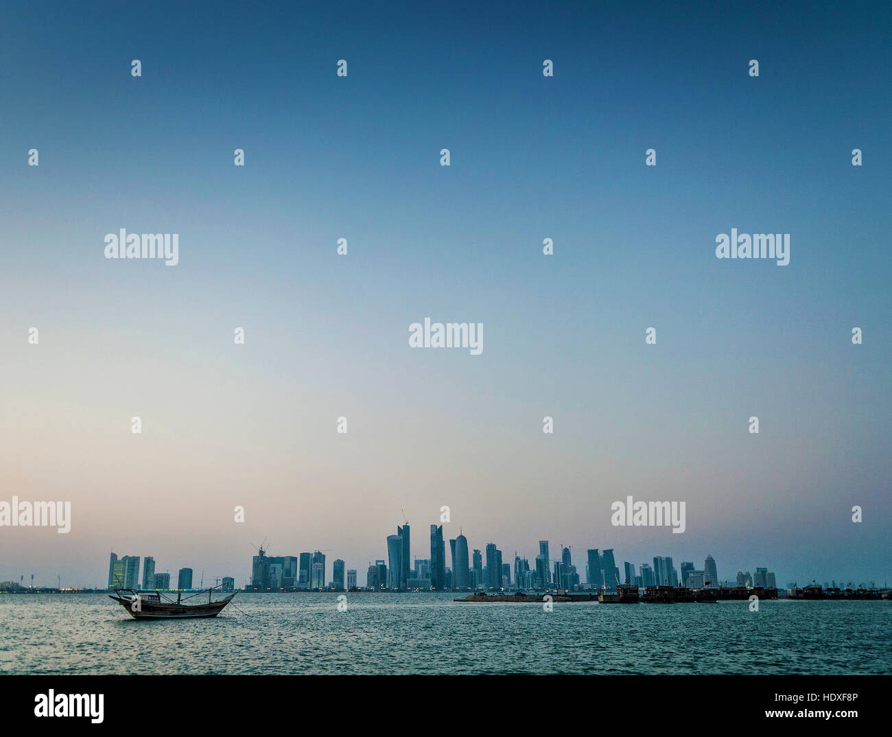 Doha grattacieli della città Urban Skyline view e barca dhow in qatar al tramonto Foto Stock