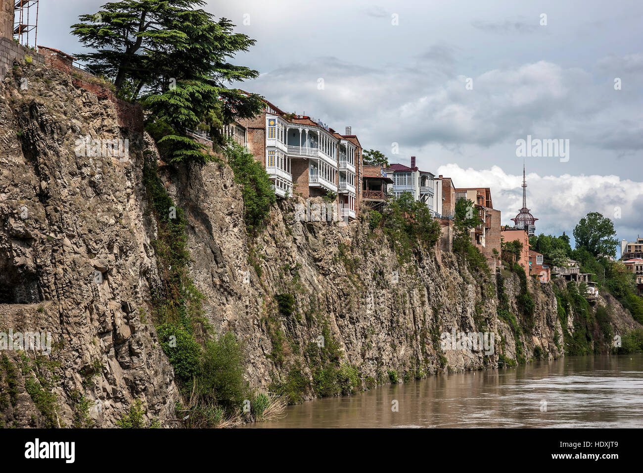 La Georgia, Tbilisi. Vista sul quartiere Avlabari , case su una scogliera , lasciando l'acqua nel fiume Kura . Foto Stock