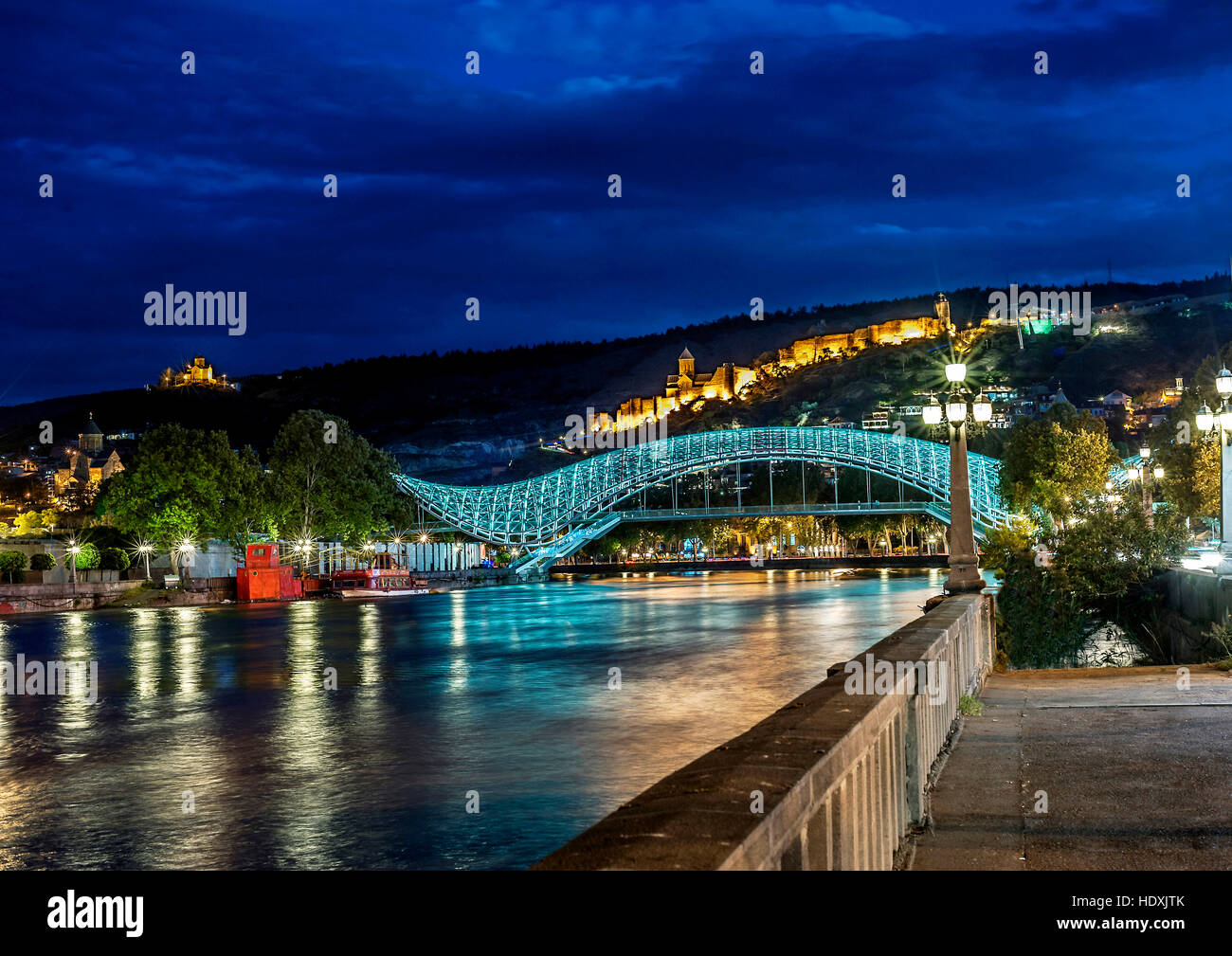 La Georgia, Tbilisi notte . Vista dal terrapieno del Kura in corrispondenza del ponte di pace , la fortezza di Narikala , Cattedrale di Metekhi . Foto Stock