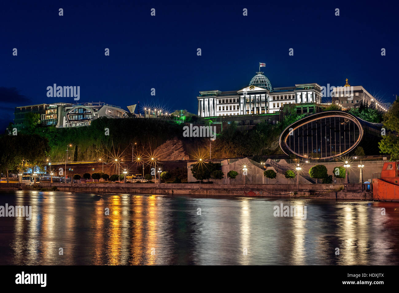 La Georgia, Tbilisi notte . Vista dalla riva destra del fiume Kura nel complesso del Palazzo Presidenziale e la nuova sala concerti . Foto Stock
