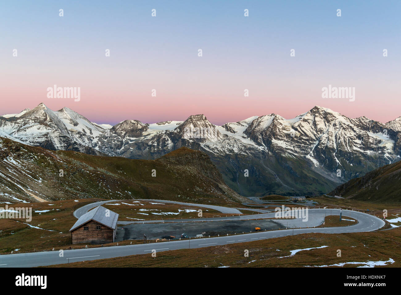 Vista della Strada alpina del Grossglockner e il Glocknergroup presso sunrise, Parco Nazionale degli Hohe Tauern, Austria Foto Stock