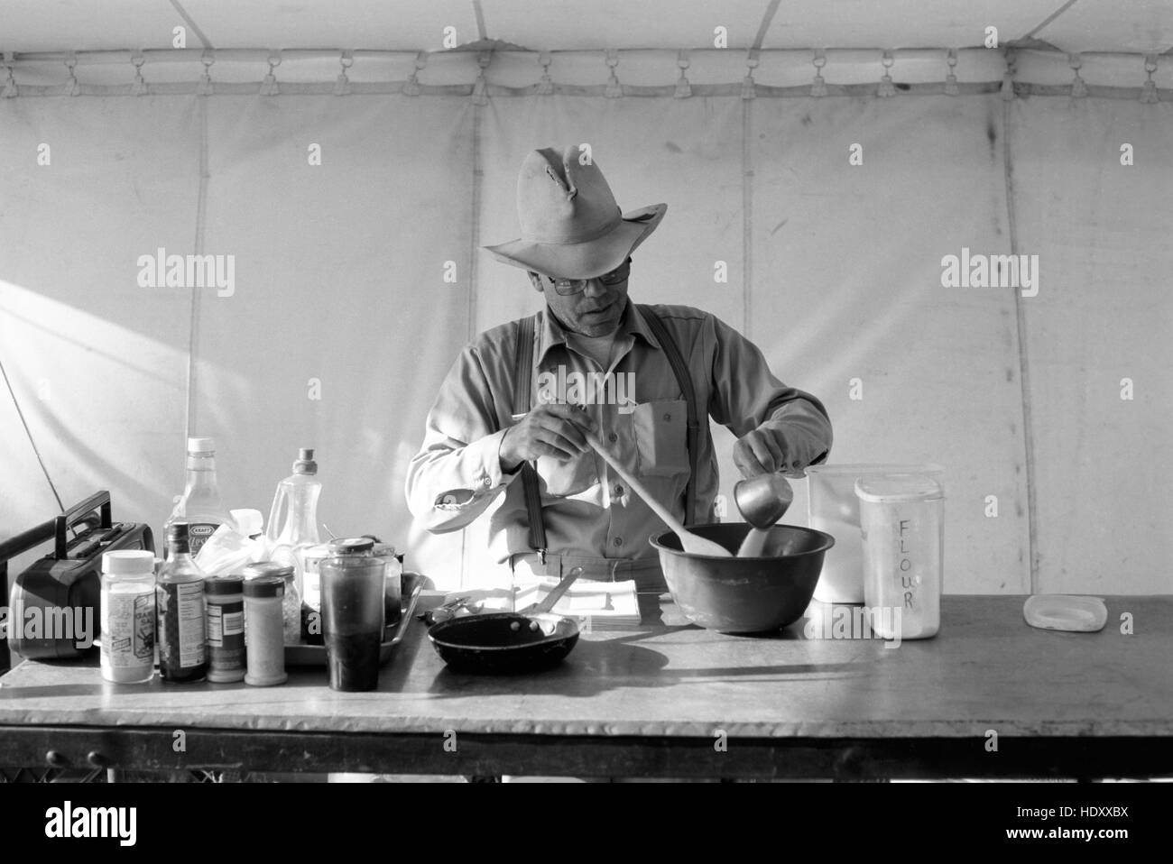 Chuckwagon cuocere mescolando gli ingredienti per un pasto dopo una molla branding alla Carta Alta Ranch in Crowell, TX (scansione dal b&w negativo) circa 1998 Foto Stock