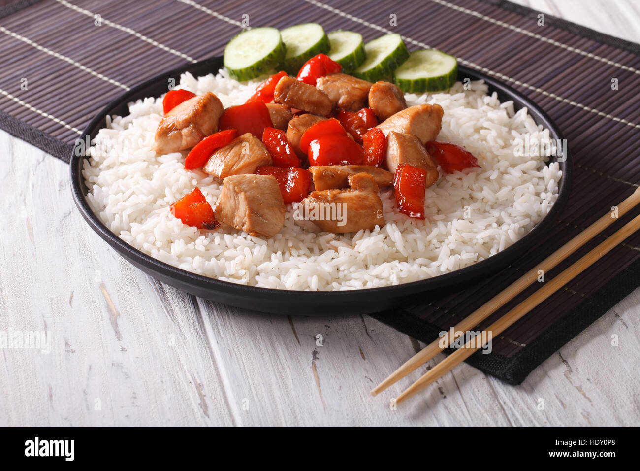 Riso con pezzi di pollo in una salsa su una piastra di close-up orizzontale. Foto Stock