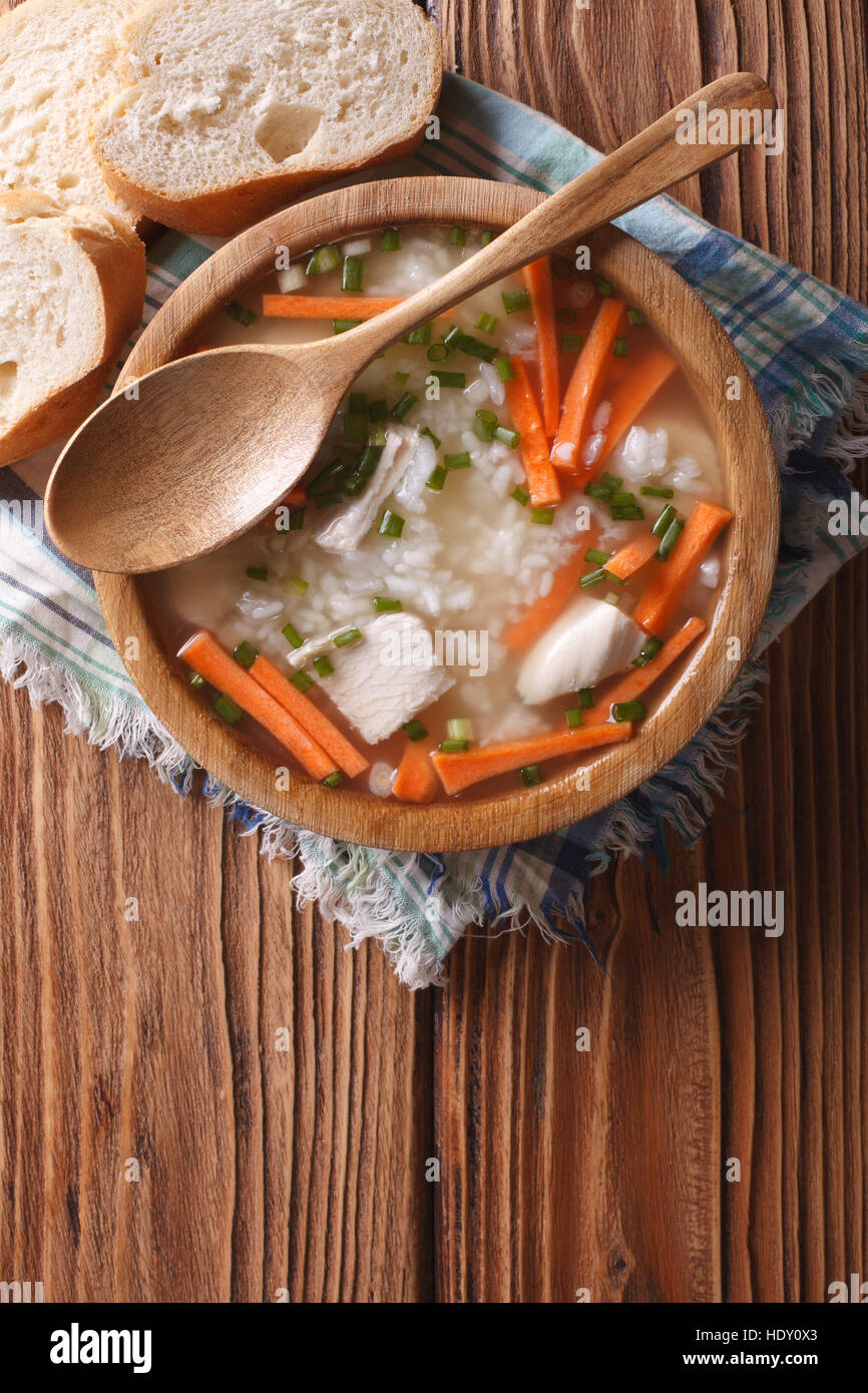 Cibo fatto in casa: Pollo zuppa di riso in una ciotola di legno. Verticale in alto consente di visualizzare Foto Stock