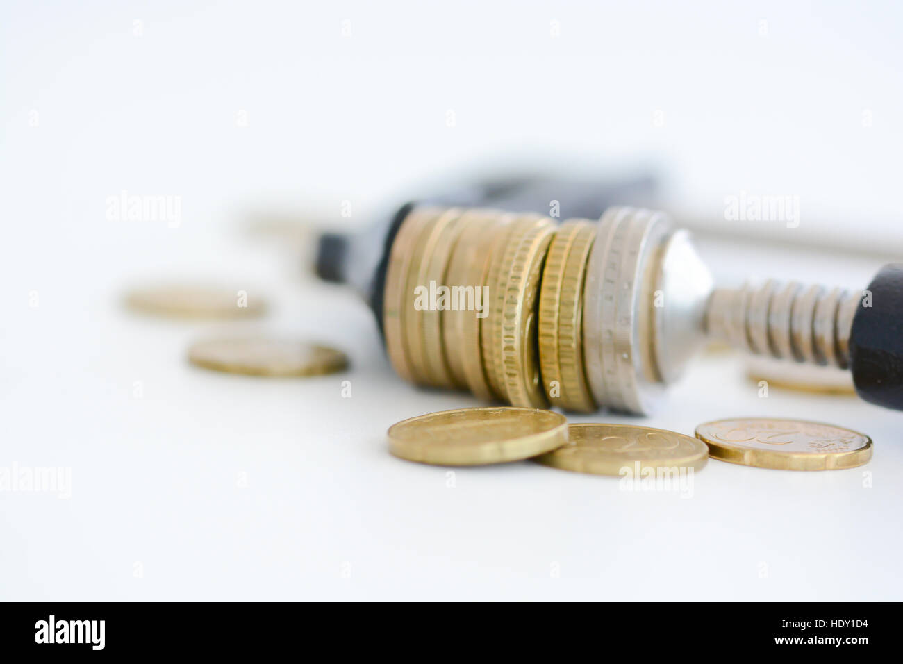 Economia concetto di pressione con la pila di monete in un crampi Foto Stock