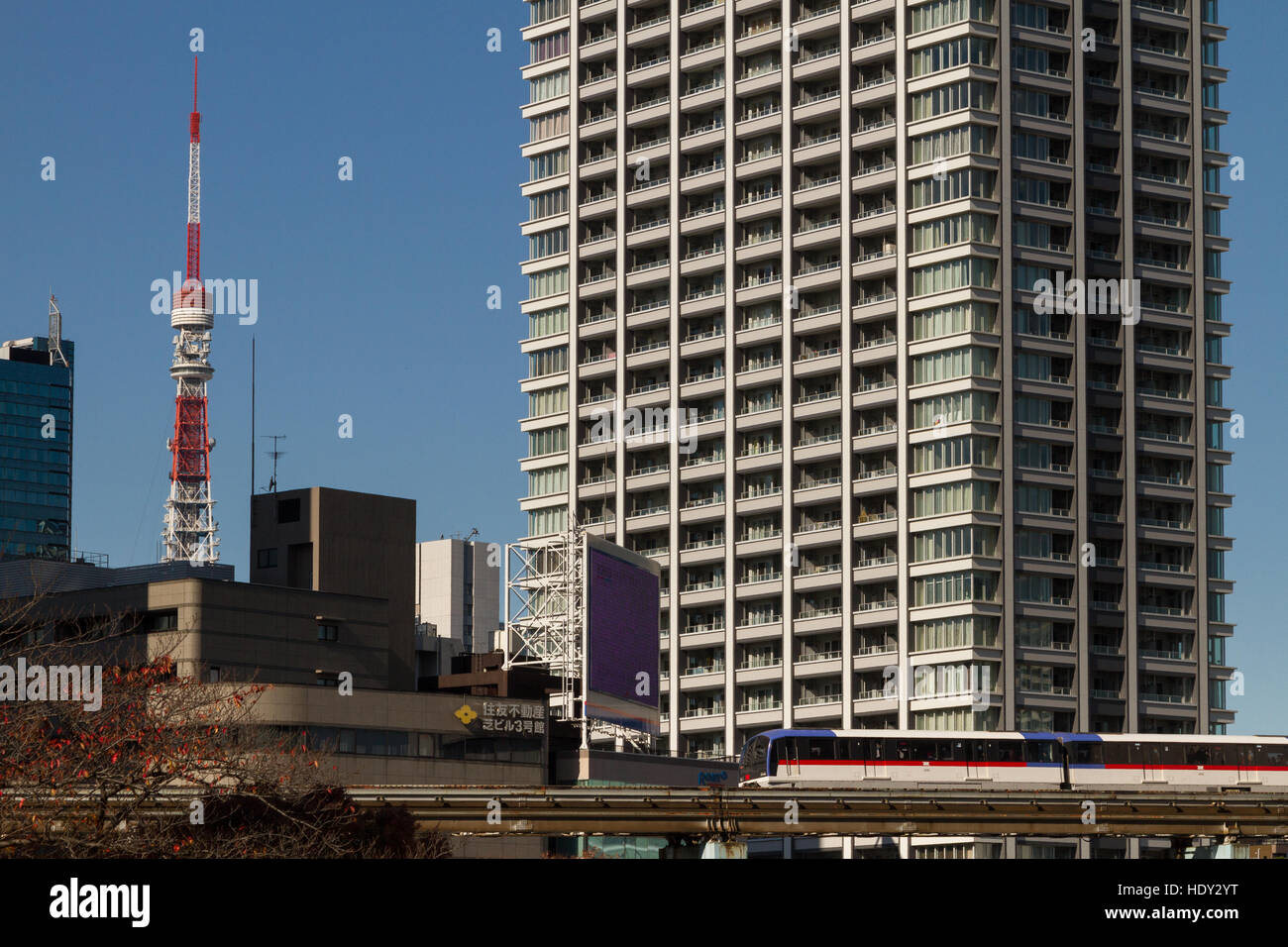 Tokyo Tower dietro gli edifici di appartamenti e un treno della linea Yurikamome a Tokyo, Giappone Foto Stock