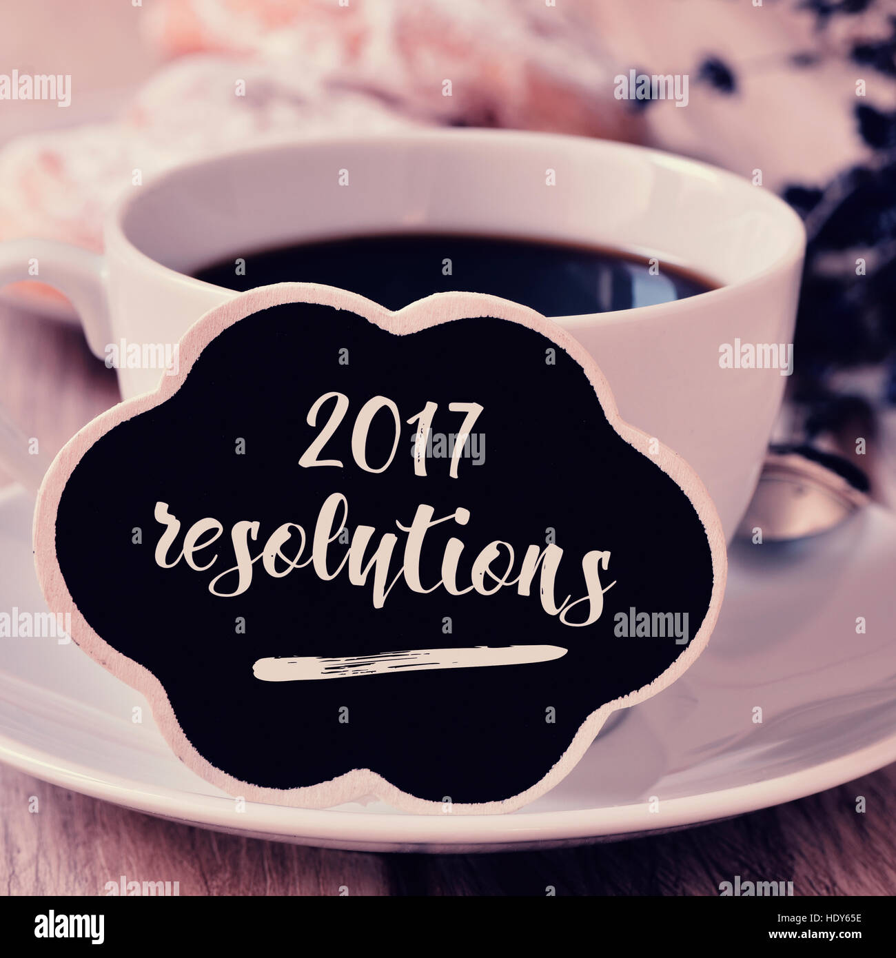 Primo piano di un cartello nero in forma di bolle di pensiero con il testo 2017 risoluzioni scritte in essa accanto a un bianco tazza ceramica con caffè sul Foto Stock