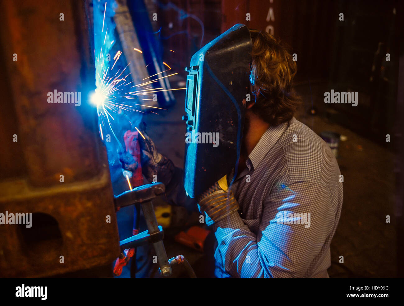 Saldatrice ad arco lavorando su una unità di forno in una macchina tedesca fabbrica. Foto Stock