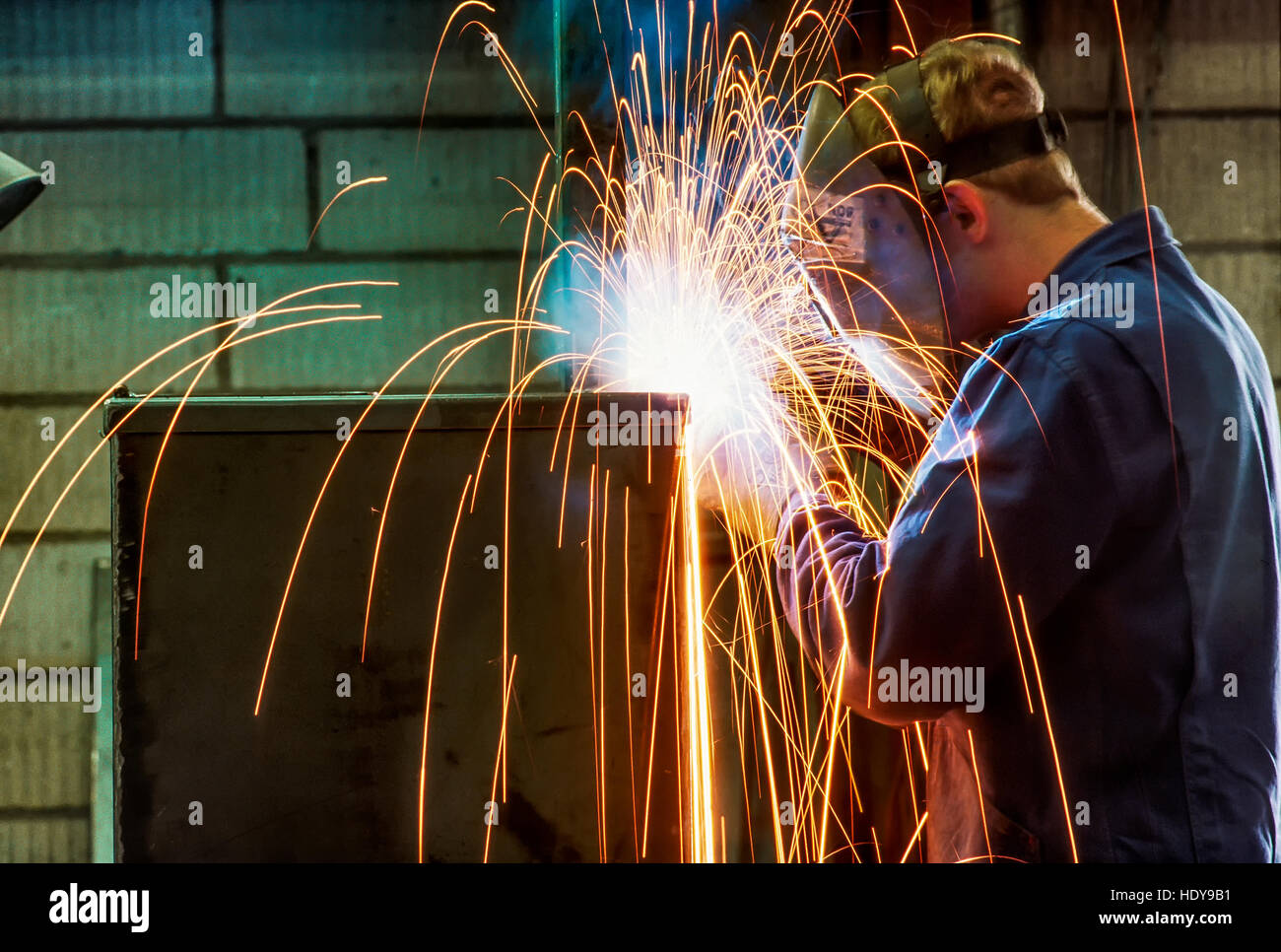 Saldatore acetilene lavorando su una unità di forno in una macchina tedesca fabbrica. Foto Stock