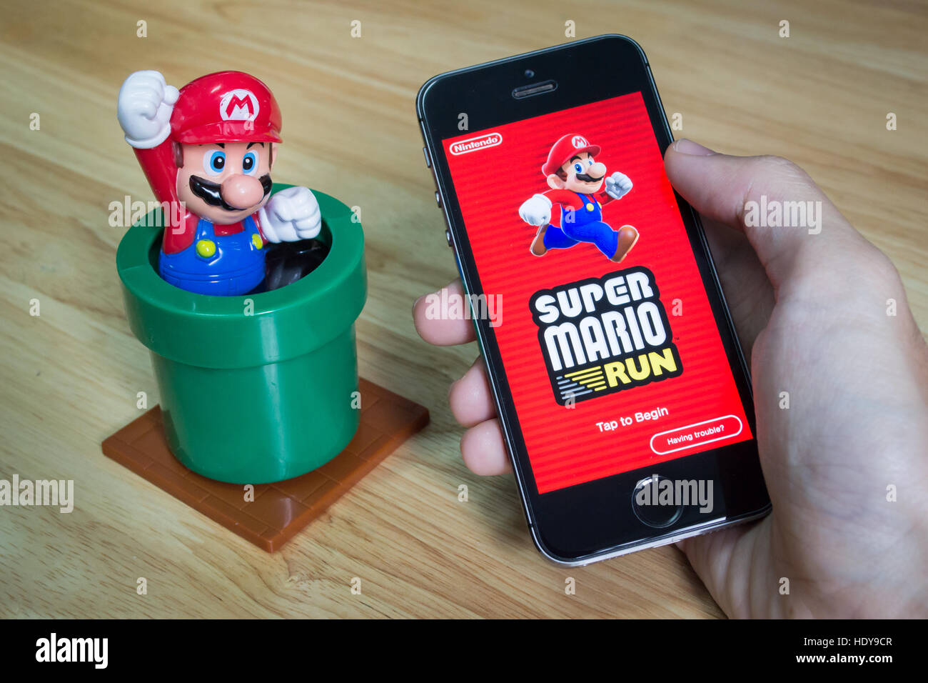 Bangkok, Tailandia - 16 Dicembre 2016 : Apple iPhone5s tenuto in una mano che mostra il suo schermo con Super Mario esegue l'applicazione. Foto Stock