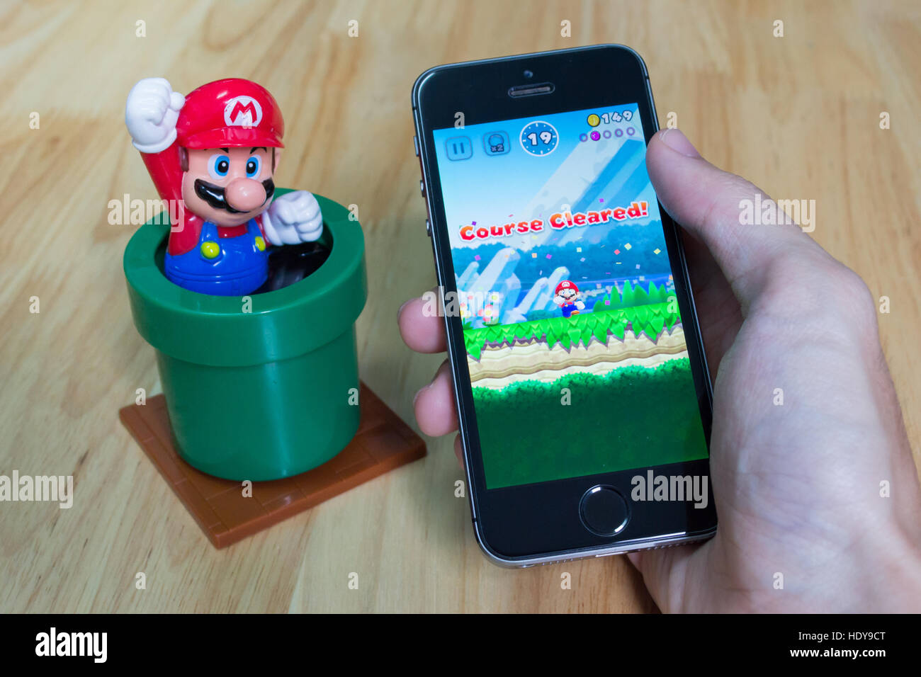 Bangkok, Tailandia - 16 Dicembre 2016 : Apple iPhone5s tenuto in una mano che mostra il suo schermo con Super Mario esegue l'applicazione. Foto Stock