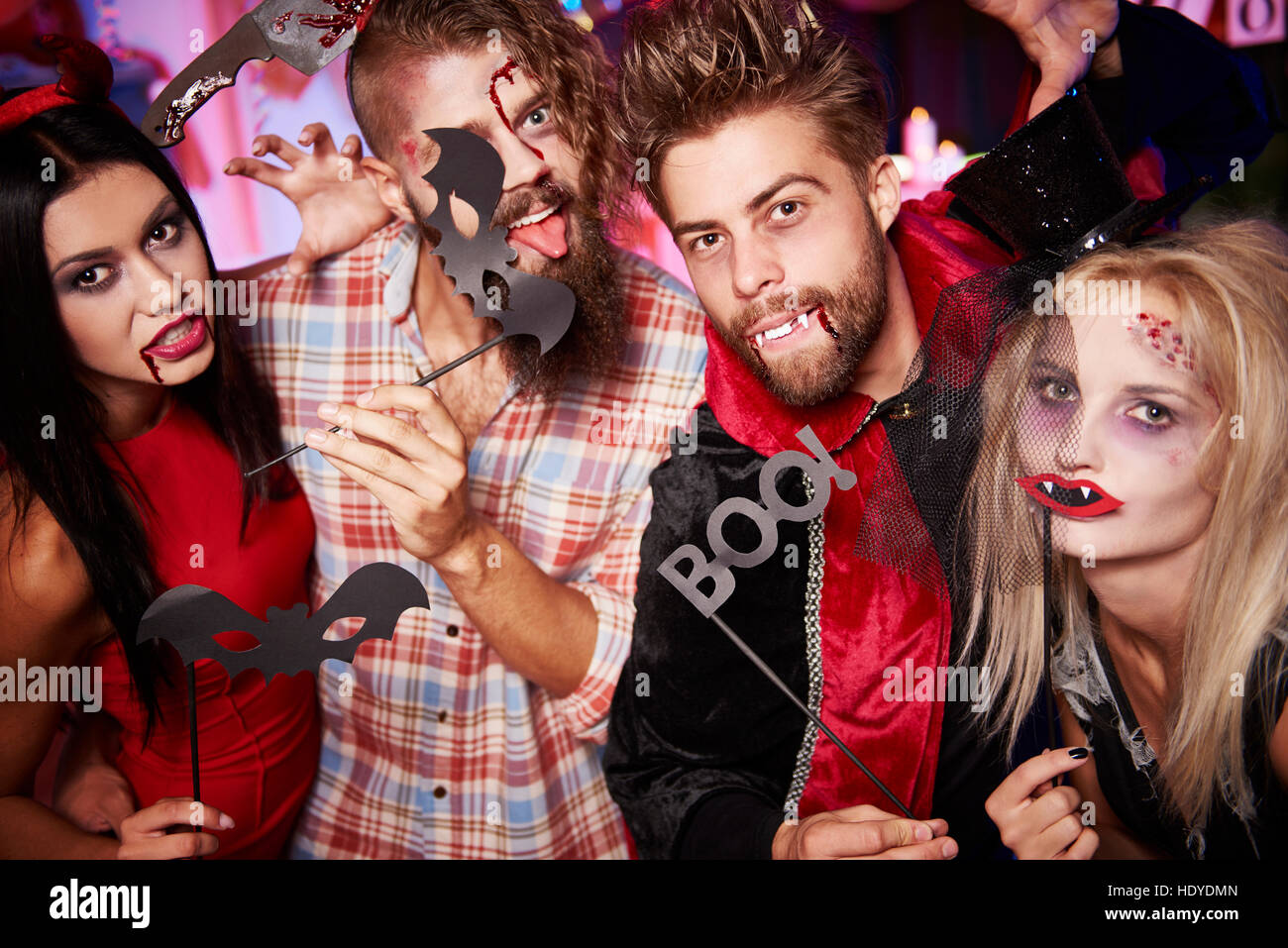 Amici in posa per una foto con maschere divertenti Foto Stock