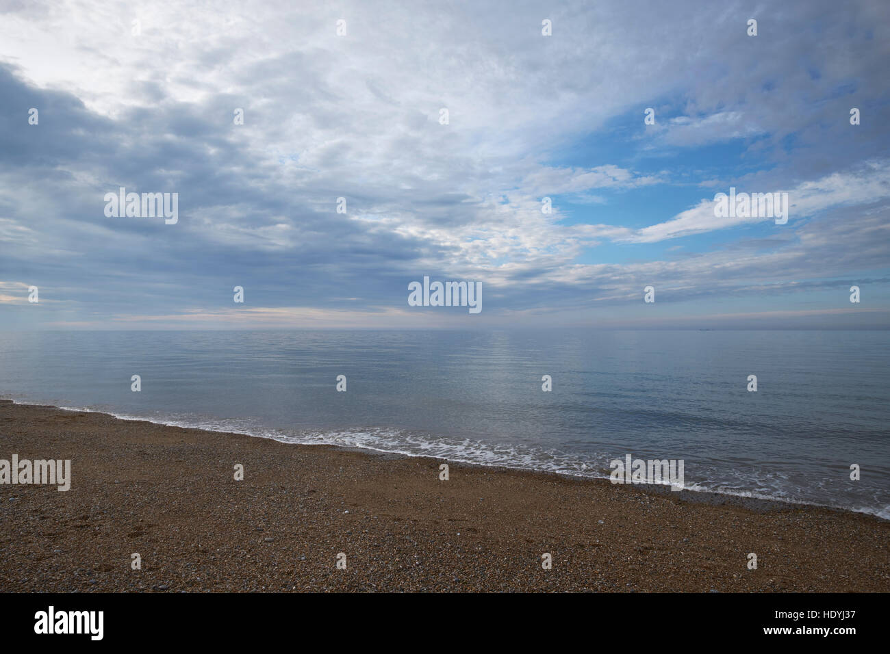 Cley-Next-il-Mare, Norfolk. La ghiaia e sabbia spiaggia, guardando verso nord-ovest al mare, con nubi stratocumulus riempie il cielo. A metà estate, 7pm. Foto Stock