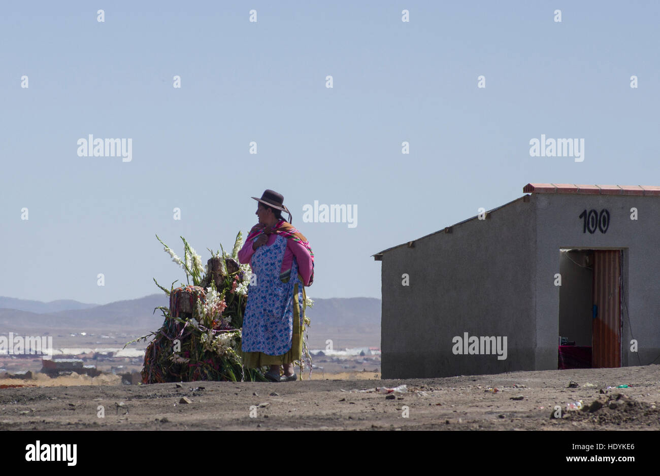 Le donne nei tradizionali abiti indigeni in corrispondenza di un luogo sacro vicino a La Paz, Bolivia, sorge accanto a un gigante mesa, offerta rituale a Dio Foto Stock