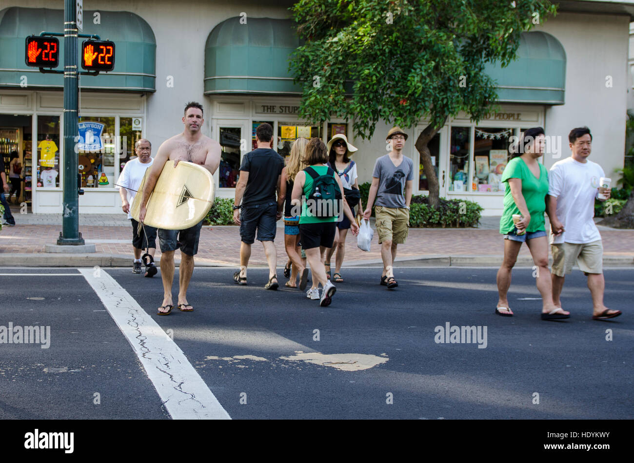 Attraversando via con la tavola da surf, Waikiki, Honolulu Oahu, Hawaii. Foto Stock