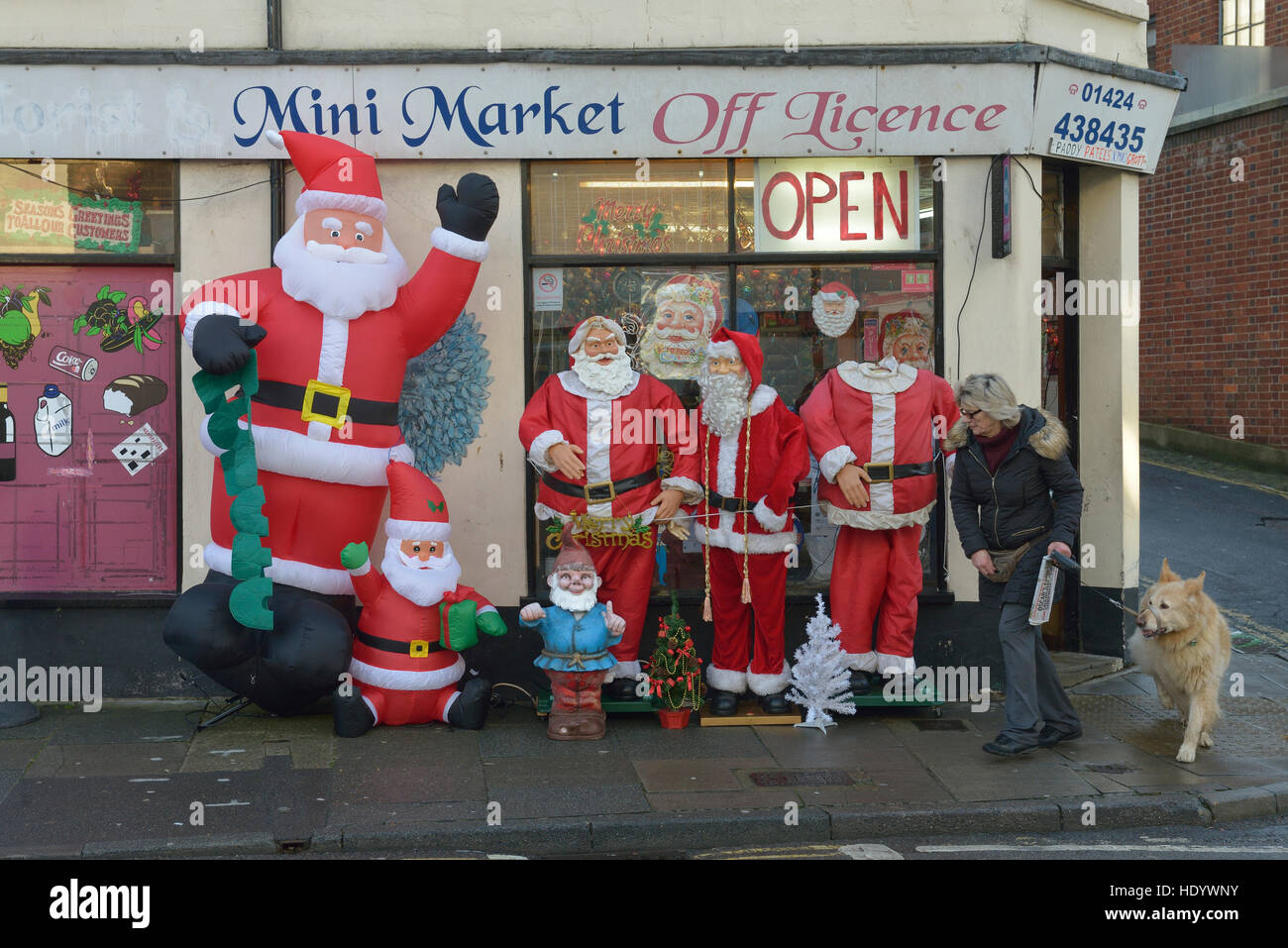 Babbo Natale figure al di fuori di un mini market store. Hastings. East Sussex. Regno Unito. Foto Stock