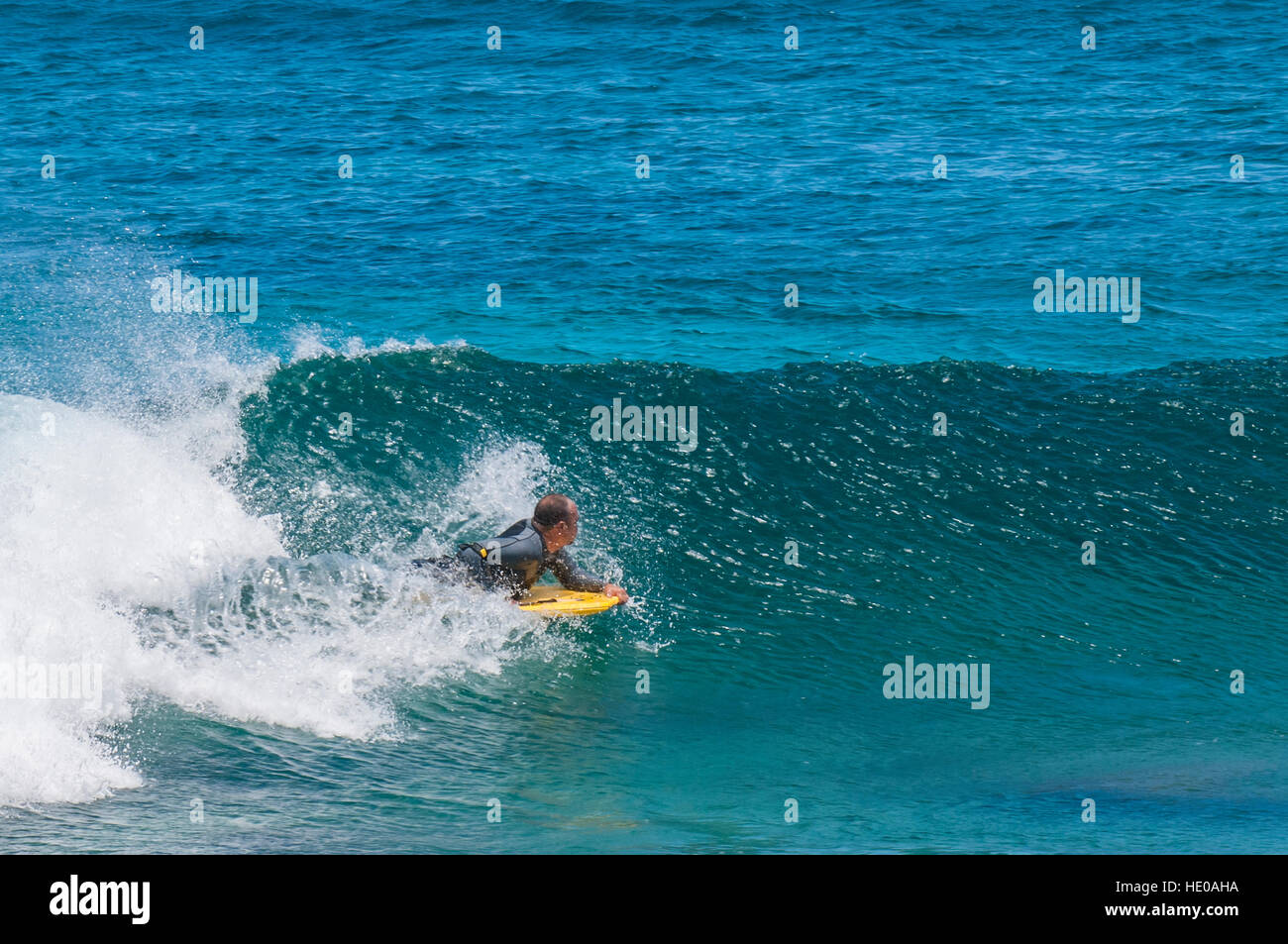 Boogie boarding wave riding al Sunset Beach, North Shore Oahu, Hawaii. Foto Stock